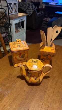 A set of three spoon holder a container and a tea pot A set of three spoon holder a container and a tea pot