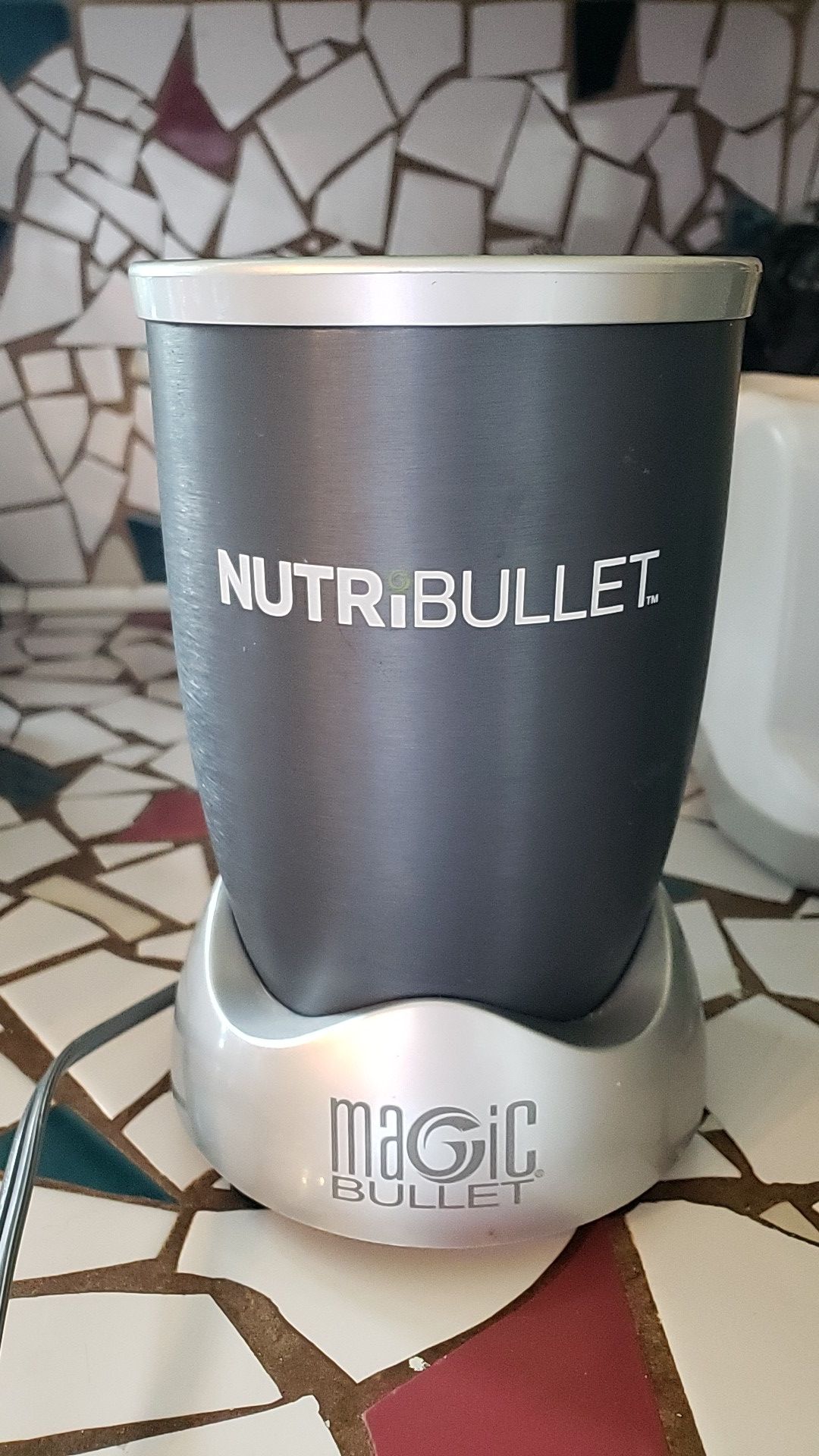 Nutribullet gray with 2 cups one with attached handle, second with removable handle.
