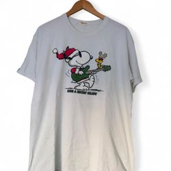 White Snoopy Christmas tee with graphic of Snoopy playing guitar with a reindeer