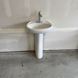 White pedestal sink with faucet