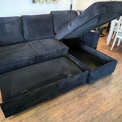 Black corduroy sectional sofa with pullout sleeper bed with cup holders 
