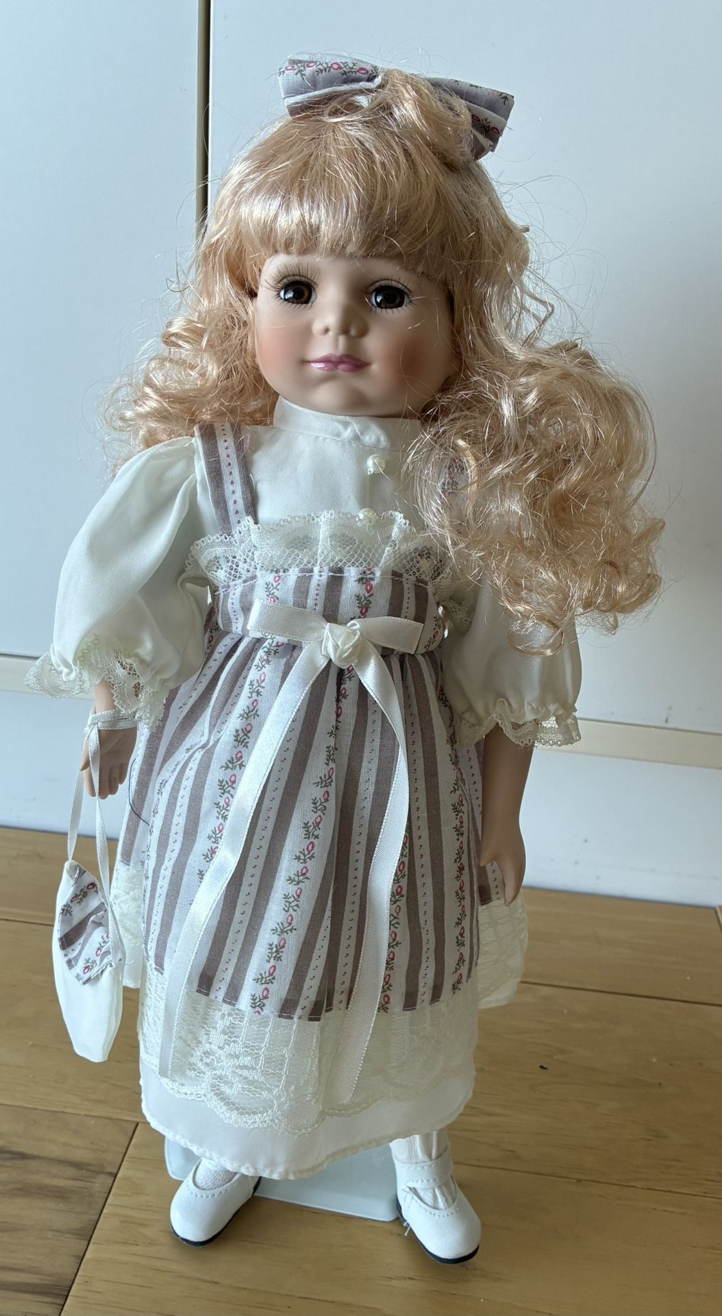Porcelain Doll, 17” Tall, Purple & White Stripe Dress w/Lace & Blouse, Long Blonde Curly Hair w/Bow.