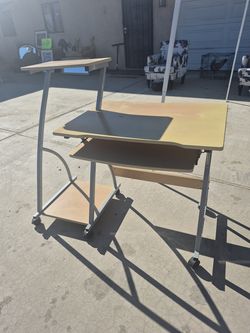 compact, mobile computer desk with a light wood-finish top and silver metal frame.