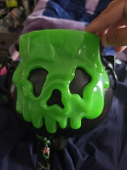 This Disney Parks Green Poison Apple cauldron popcorn bucket features a bubbling green skull design that lights up.