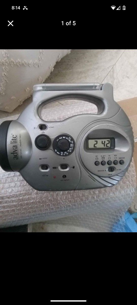 Adva Lite solar-powered radio with a flashlight and digital clock. It's designed for use in emergencies or areas with limited power access.