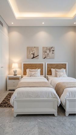 Set of two twin beds with new mattresses and a nightstand.