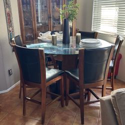 Glass table with six chairs and a sideboard hutch