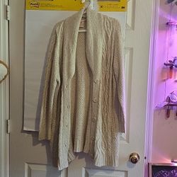 A beige long sleeve cable knit cardigan sweaters with front buttons and pockets.