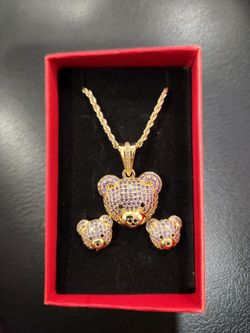 Fashion gold-plated teddy bear necklace and earring set adorned with purple cubic zirconia stones.
