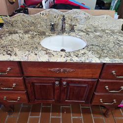 Vanity para baño de madera y granito.