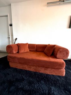 Burnt Orange Sleeper Sofa + Soft Black Rug