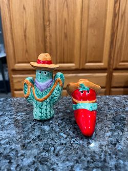 Ceramic Novelty Cactus and Red Chili pepper wearing hats pair of Salt and Pepper Shakers. Preowned. Size approximately 3 inches tall the Cactus. Ha