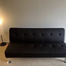 Black convertible sofa bed with built-in USB charging port.