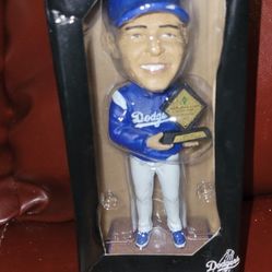 Los Angeles Dodgers Dave Roberts bobblehead figure. 
It is a collectible item typically given away at Dodger Stadium promotional events.
The figure de