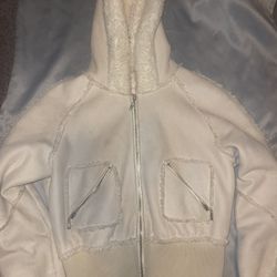 Cream and white Sherpa hoodie with zipper pockets.