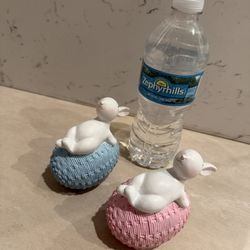 Set of 2; Easter Bunny figurines as they lie on the egg