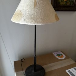 Vintage 21” tall dark bronze candle stick style table lamp with dried leaf shade. 