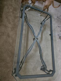 Beveled glass top coffee table and matching sofa table with an ornate metal base.