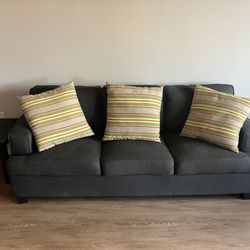 Grey Couch With Striped Cushions 
