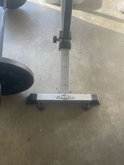 Tuff stuff work out bench and two 25 lb weights and 25lb bar