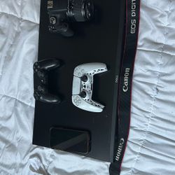 Iphone xr 2 playstation controllers cannon camera and a monitor 120 hz