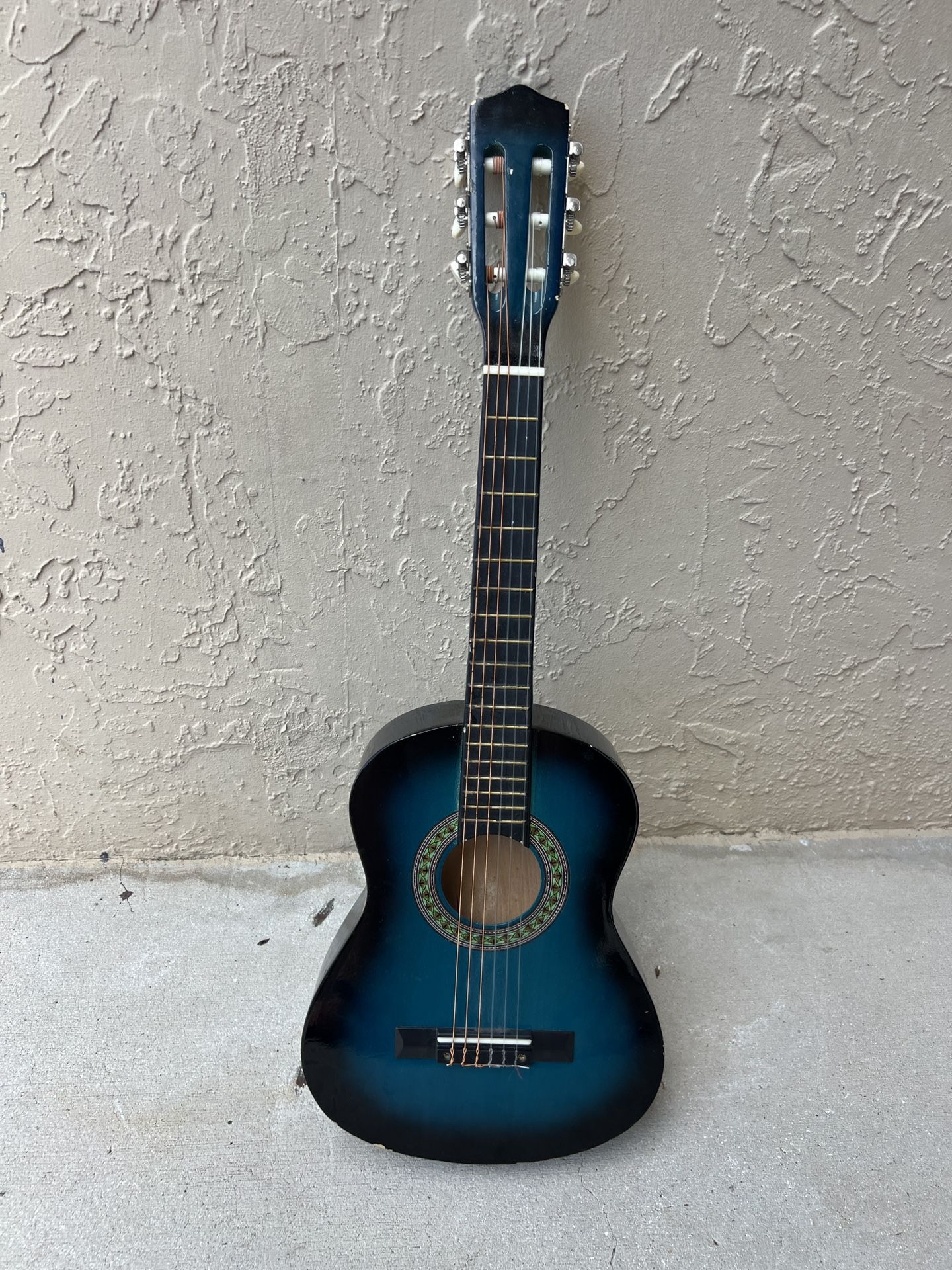 Children's or teenager's guitar. Three iron strings, three plastic. Will teach excellently. Small chips