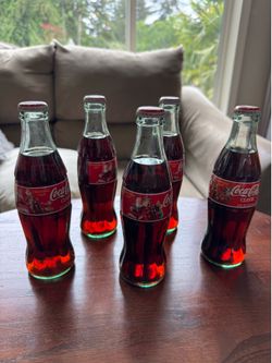 Vintage Coca-Cola Christmas 1998 collectible glass bottles.