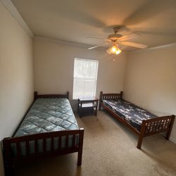 2 twin bed frames with 2 mattress and a night lamp