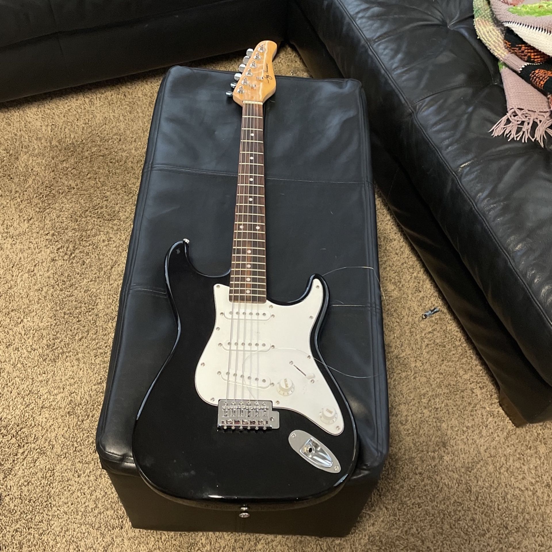 Black and white electric guitar with amp and bag