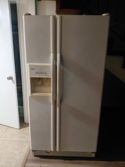 White Kenmore side-by-side refrigerator has an external filtered ice and water dispenser with Acceler-Ice technology. This appliance is a dual-door mo