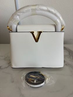 white bag with a gold neck line and a shoulder strap