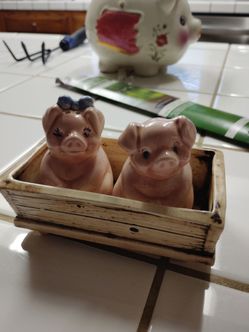Pigs sitting in crate salt pepper shakers