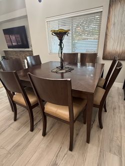 Ladlow solid brown wood table with 8 tan leather chairs