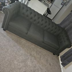 gray tufted sofa in a Chesterfield 