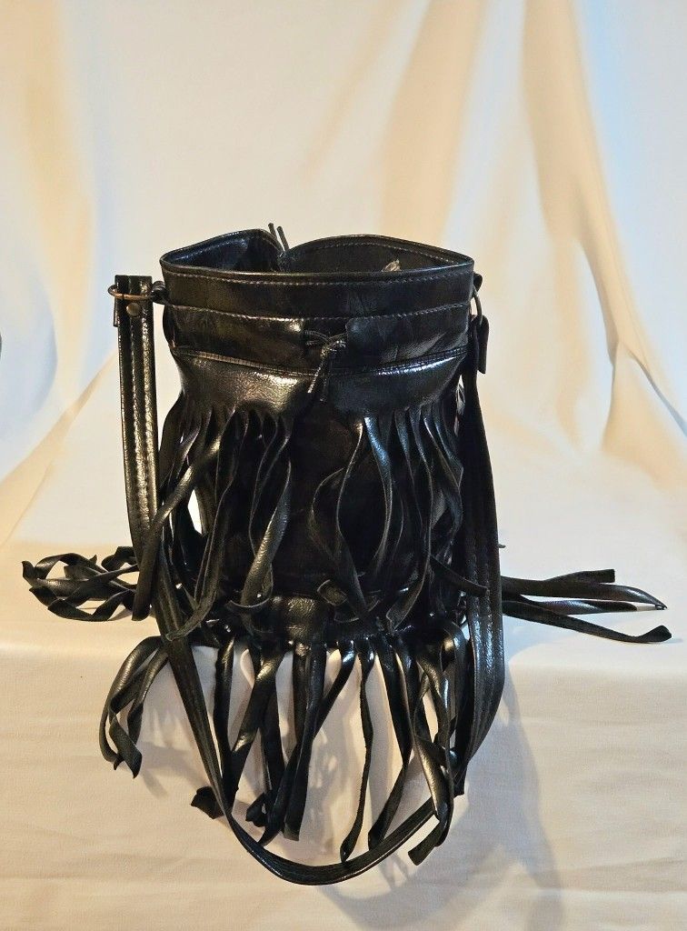 Black Woman's Purse Fringed Drawstring Faux Leather This black woman's purse is a stylish and trendy option for casual occasions, featuring fringe acc