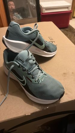 These are Nike Women's Downshifter 13 Running Shoes in a light blue or green color