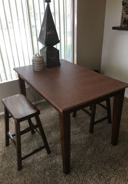 Dark wood Moroccan top dinner table with two solid wood stools.