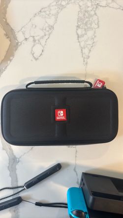 Nintendo Switch OLED model with neon red and blue joy con, case and charger