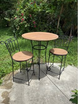 This French country-style chair features a wrought-iron frame and a wooden seat.
