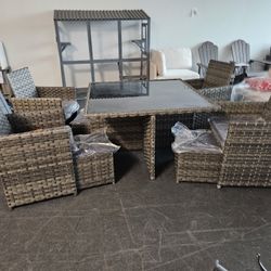 7-Piece Outdoor Wicker Dining Set – Glass Top Table w/ Storage Ottomans