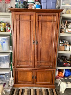 Craftsman style wood armoire .