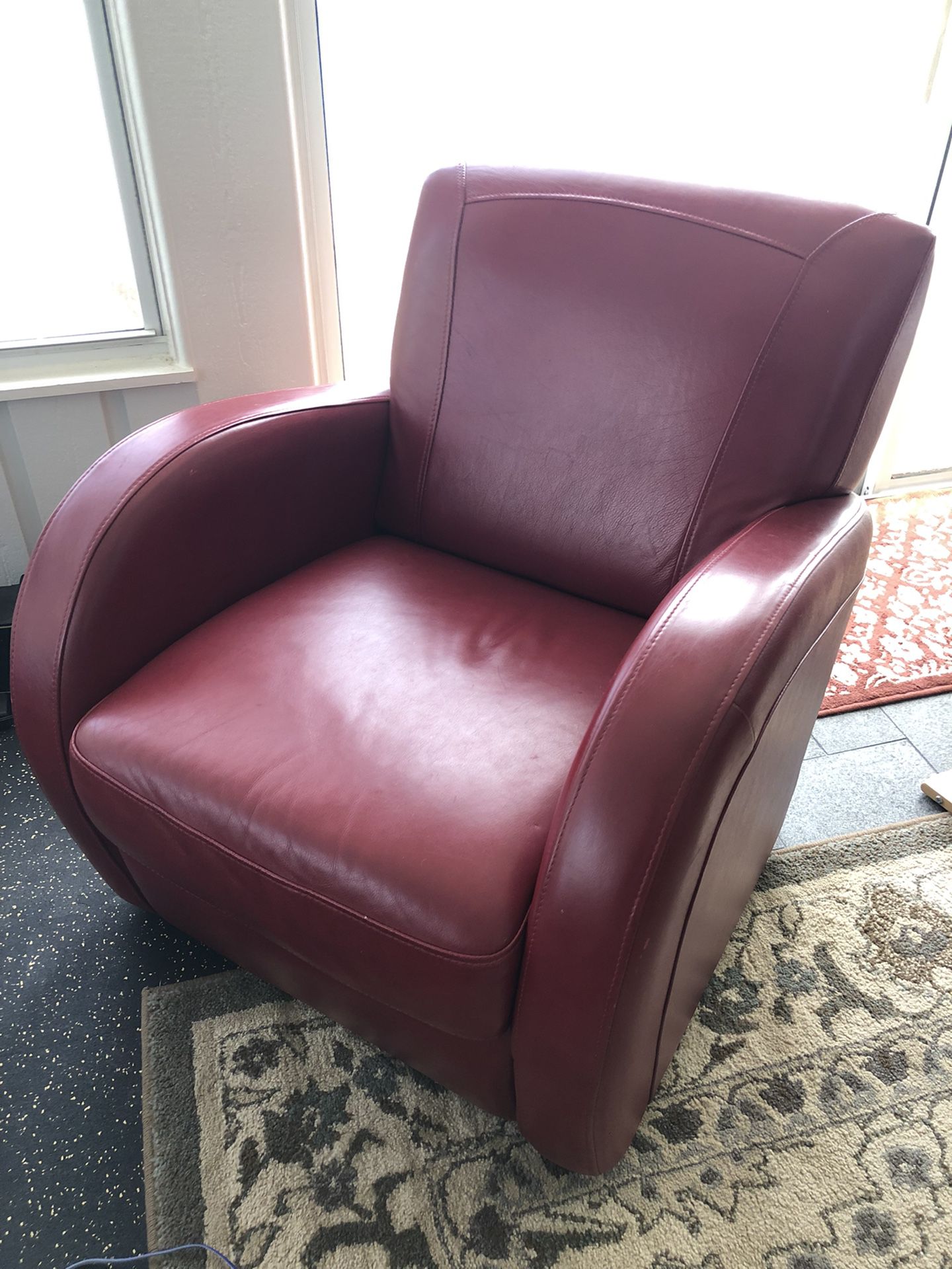 Pair of swivel red leather armchairs