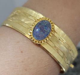 vintage Australian opal triplet set in a 22-carat hard gold plated textured bangle bracelet, often dating from around the mid-20th century