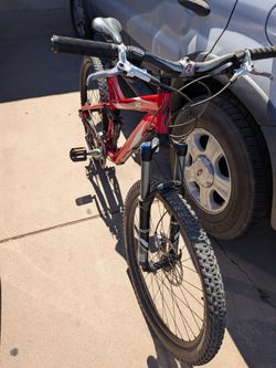 This bike is a Specialized FSR XC dual-suspension mountain bike, a classic and highly acclaimed model. It stands out for its distinctive red and white