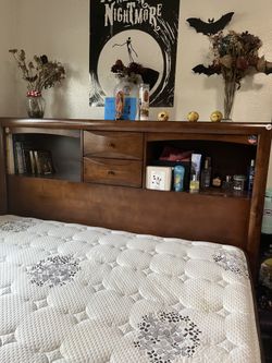 Wooden queen bed frame with lots of storage on the side with drawers and on top too
