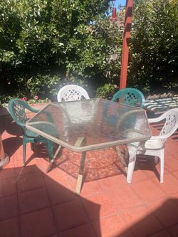 Glass top patio table with 4 chairs and umbrella stand