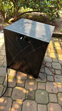 Outdoor metal table which conceals propane tank.