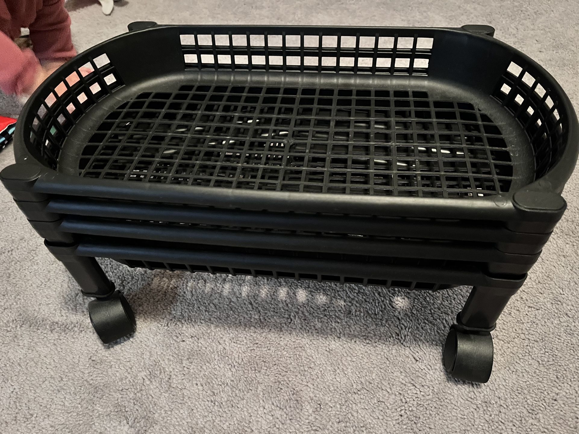 2 Black four-tier organizer trolley. This is a floor trolley with basket shelves and wheels for movement.  