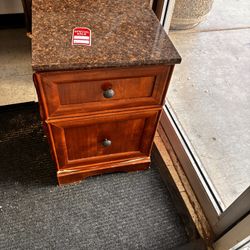Elegant wooden nightstand or side table with a dark marble-patterned top