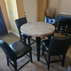 Pub table four leather chairs.